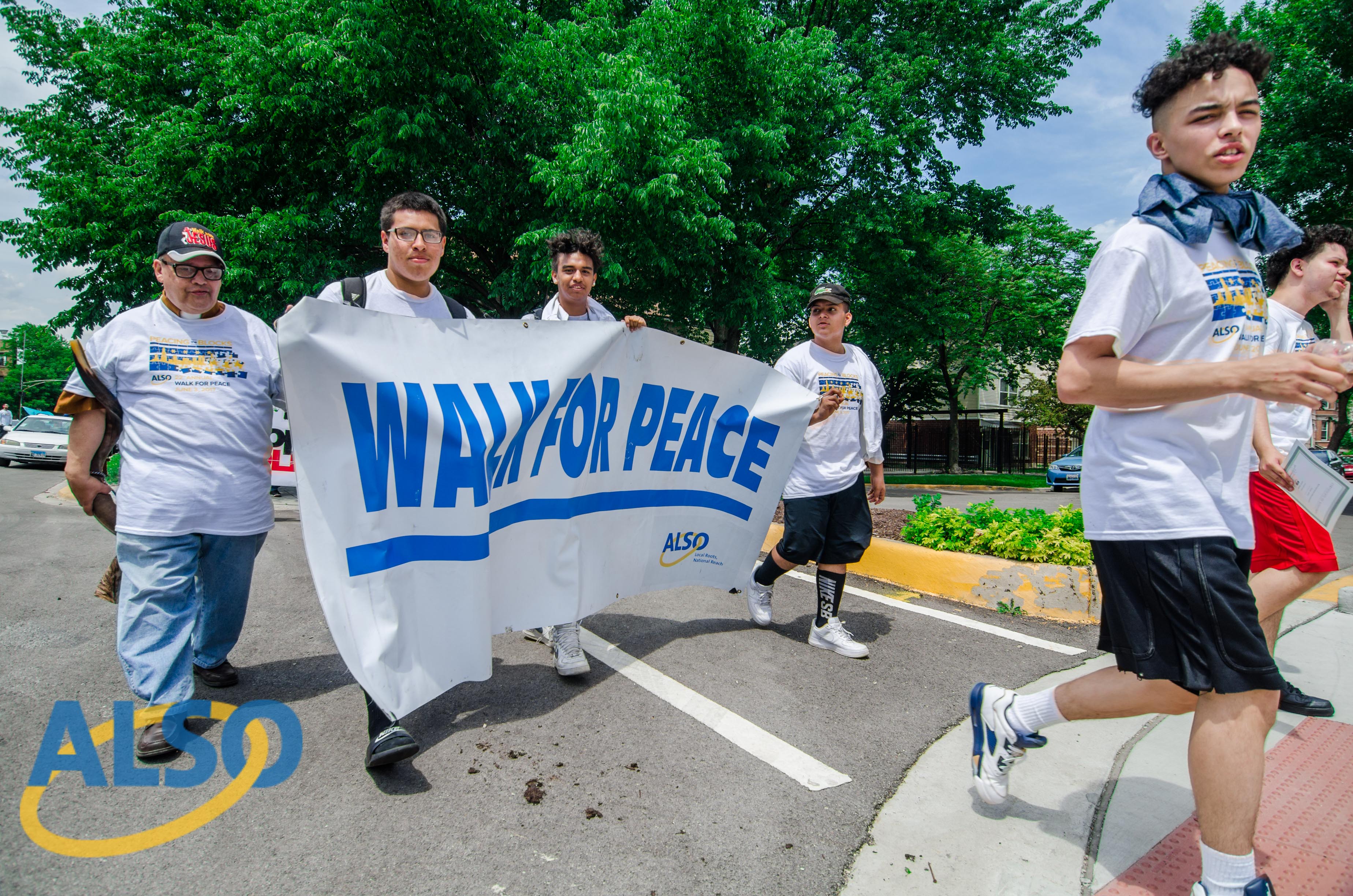 People walking with banner that says Walk for Peace